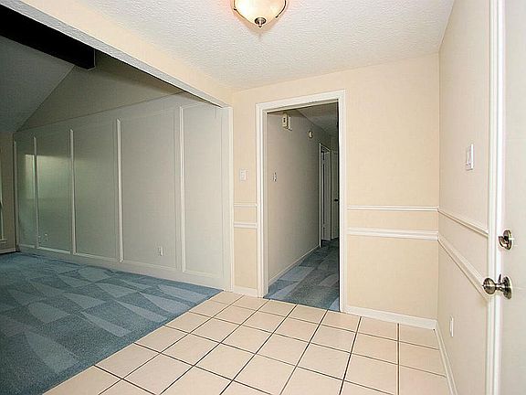 A view of the very open foyer that features tile floors and fresh paint (walls & trim)!
