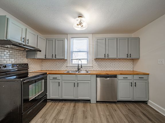 Kitchen with stainless steel dishwasher and butcher block counter tops