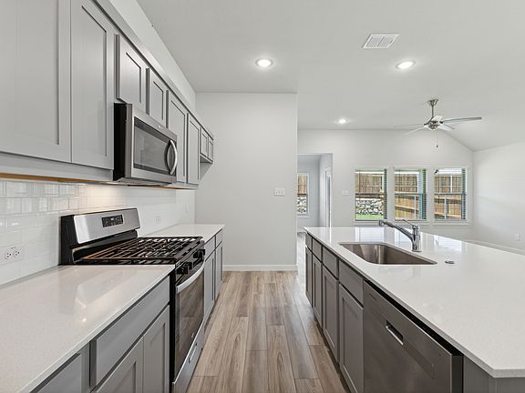 Kitchen in the Quartz home plan by Trophy Signature Homes - REPRESENTATIVE PHOTO