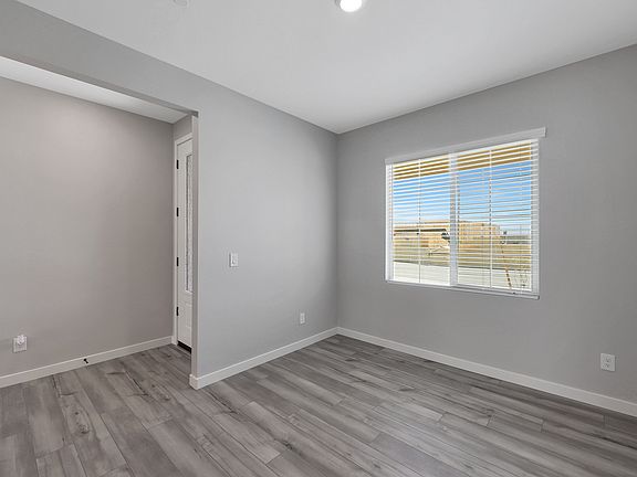 Dining room located off of the entry with large windows and wood-style flooring.