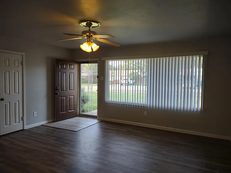 Oversized living room with tile area at door, coat closet, storm door, very large picture windows.