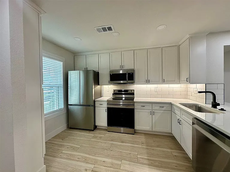 Full kitchen with all major appliances including refrigerator freezer, range, microwave and vent, dishwasher, and garbage disposal.