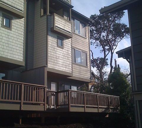 View of the rear side of the house, note the large deck and two balconies.