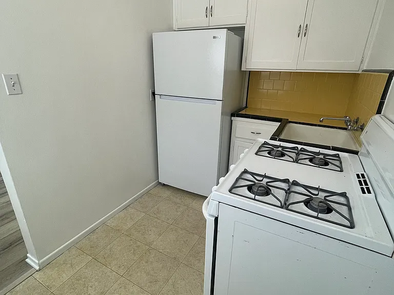 Kitchen with brand new 18 cu ft refrigerator. Room for small eat-in table next to stove.