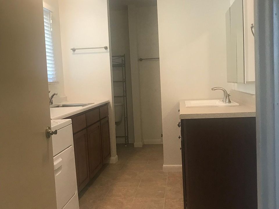 Large laundry and vanity area of bathroom with dual sinks.