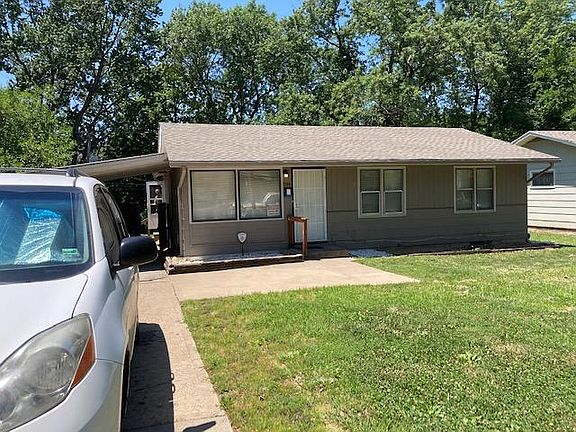 Front with carport and concrete driveway