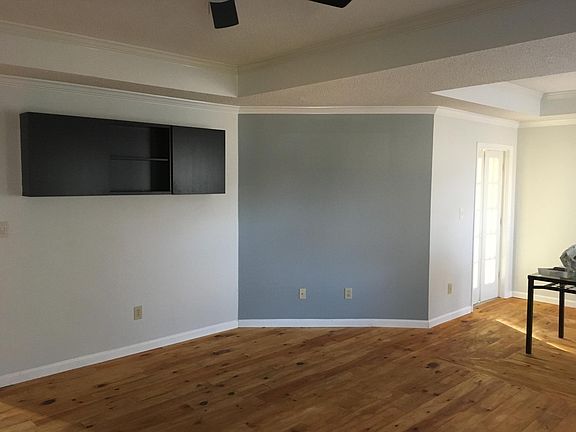 Living room with pine flooring. Wall cabinets stay.