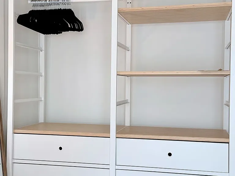 Spacious closet with shelving, drawers, and hanging space to keep belongings organized during your stay.