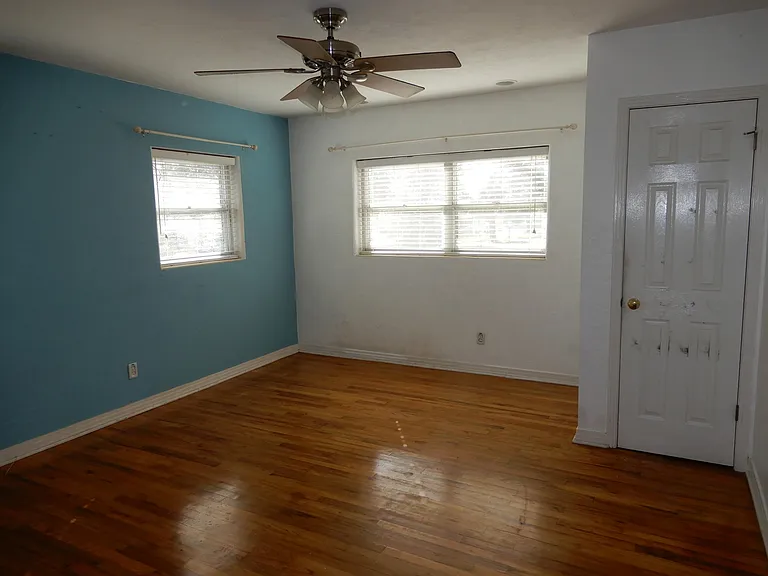 Bedroom #1, showing south and west facing windows and ceiling fan with lights.
