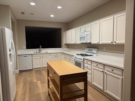 View of Kitchen from dining area and pass through bar to living room.