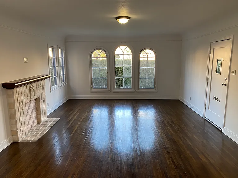 Living Room with Vintage Faux Batchelder Fireplace and Arched Casement Windows