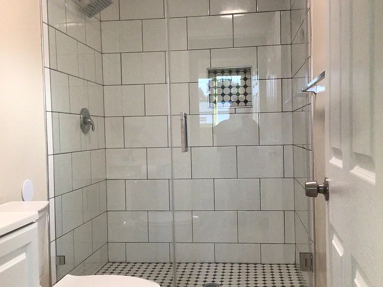 Bathroom shower with glass door.