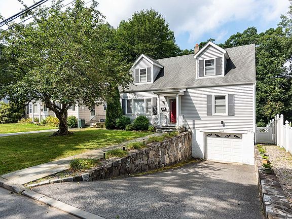 Flat front yard with pathway to the fenced backyard.
