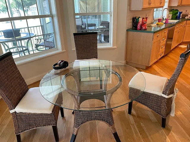 This is the breakfast nook table and chairs, just off of the kitchen with the main screen porch beyond.