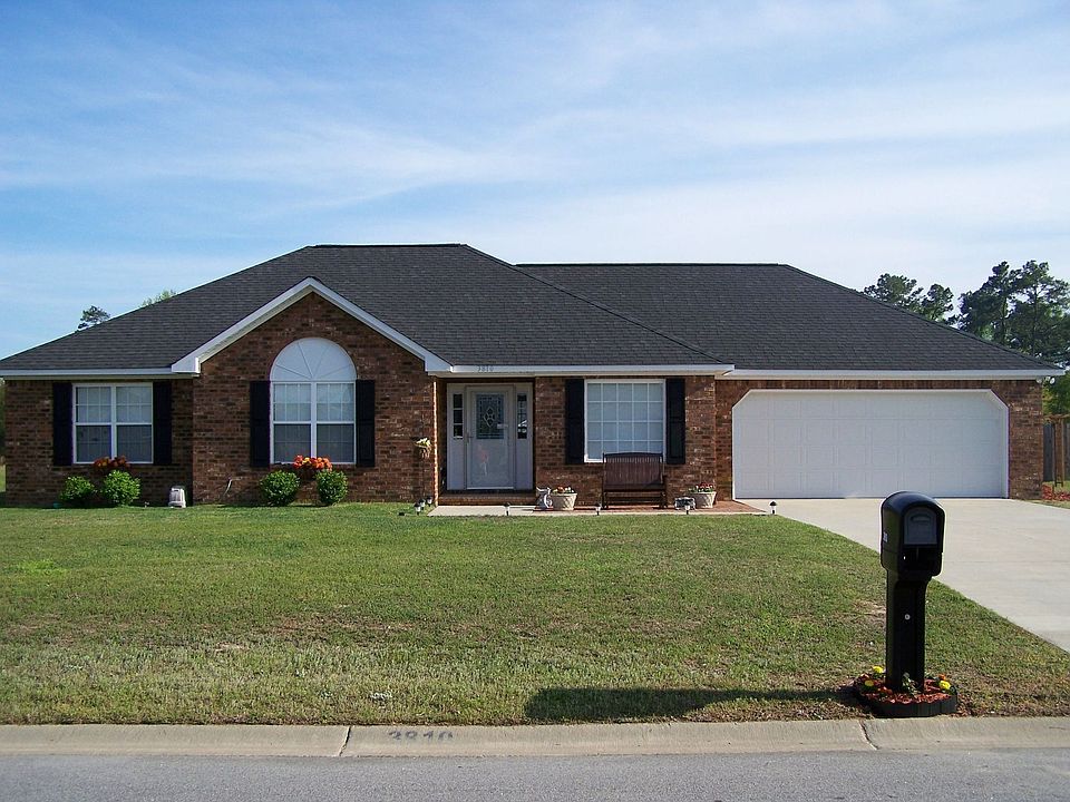Front of home, brick patio with swing bench