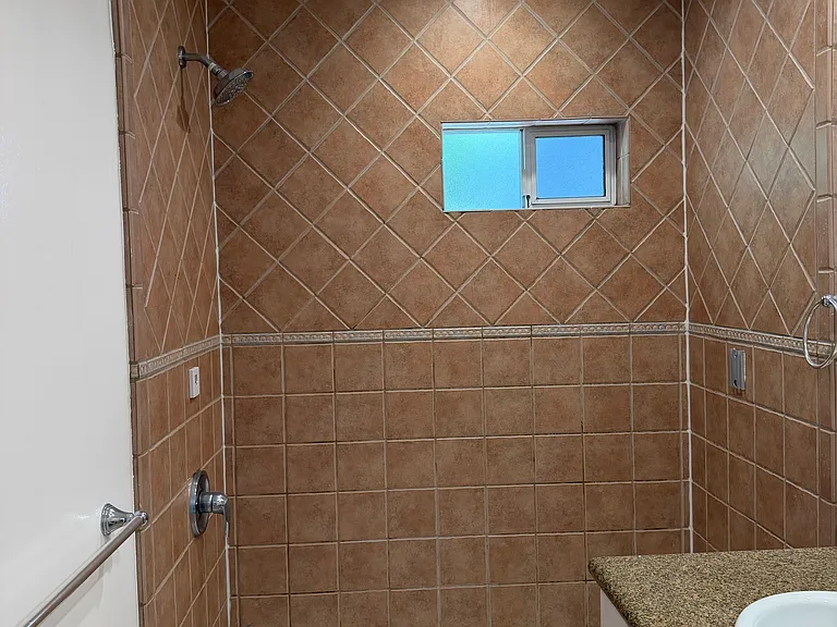 BATHROOM HAS DESIGNER TILE, NEW VANITY, GRANITE COUNTERTOP, LIGHTING AND DECORATIVE MIRROR