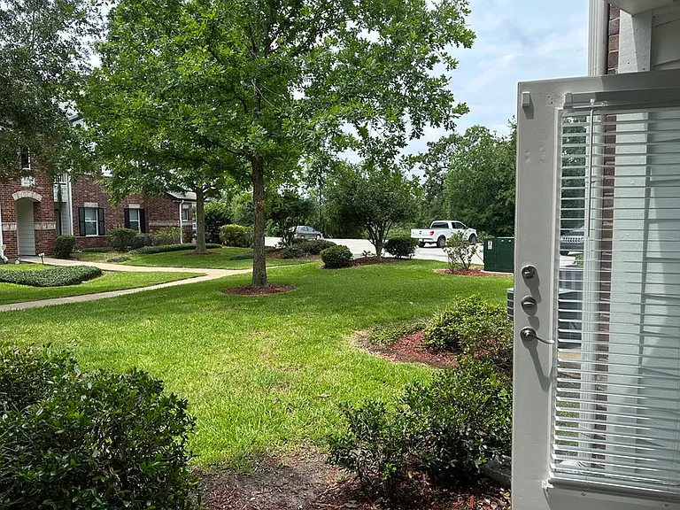 Inviting view from an open door showcasing lush green landscaping and elegant brick architecture, perfect for nature lovers. Inviting view from an open door showcasing lush green landscaping and elegant brick architecture, perfect for nature lovers.