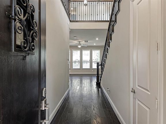 Beautiful two story entry into this high end townhome. Powder bath is situated just to the right of the front door. And note the fully functioning peek a boo tiny door on the entryway door for greeting visitors!