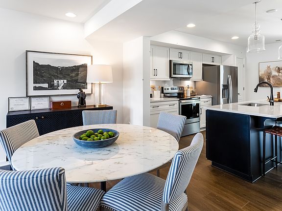 Open kitchen and adjoining breakfast area with medium toned wood floors, recessed lighting and penda