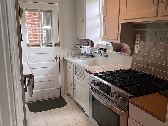 Kitchen, door to enclosed backyard. Recently purchased stove, fridge, and microwave.