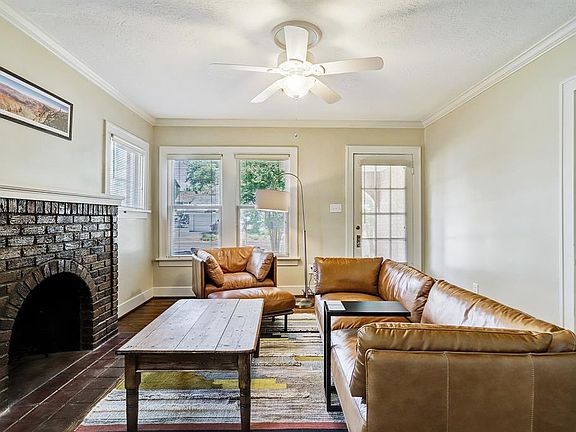Enter the front door into a cozy formal living room with a beautiful brick fireplace.