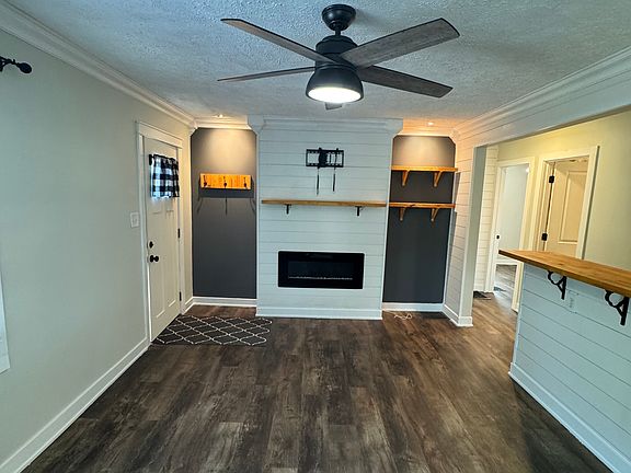 Built-in electric fireplace, included tv mount that fits up to a 50 inch tv. Built-in mantel, bookshelves, and coatrack.