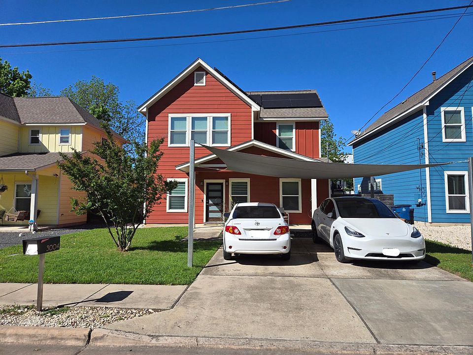 Front of house. Solar panels, covered parking and Tesla charger!