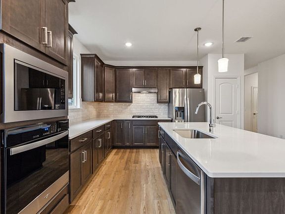 Airy kitchen with ample cabinet space with oversized island real home pictured