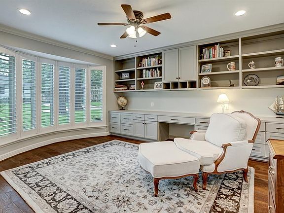The expansive private study, with a wall of built-ins, offers natural lighting and a soothing view of the front yard from the soaring windows. This versatile space could also serve as another bedroom.