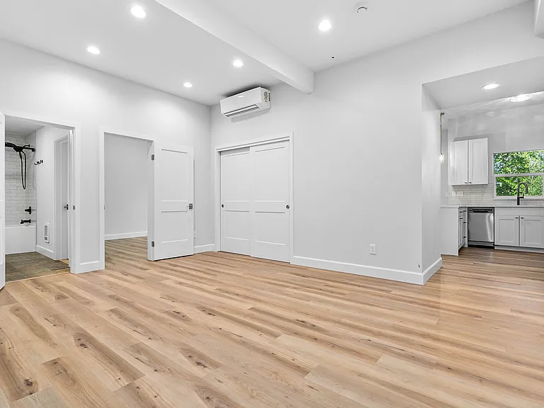 Living room. Shows entrance to kitchen. Closed doors to storage closet.