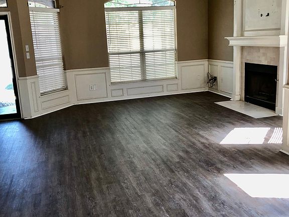 Open living/dining area with fireplace. New vinyl plank flooring.