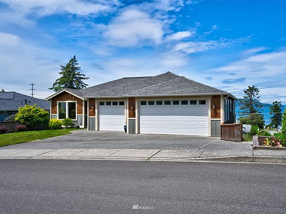 The large 3-car garage has plenty of space for your vehicles and hobby equipment, plus a shop space available down the stairs to the right of the garage
