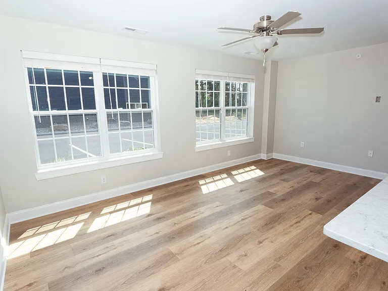 Living room located at the front of the building with view of parking area.