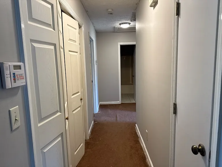The hallway to the bedrooms. On the left indoor laundry room, to the right a coat closet.
