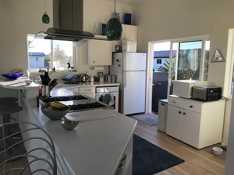 A sunny, modern kitchen with a Wolf rangetop.