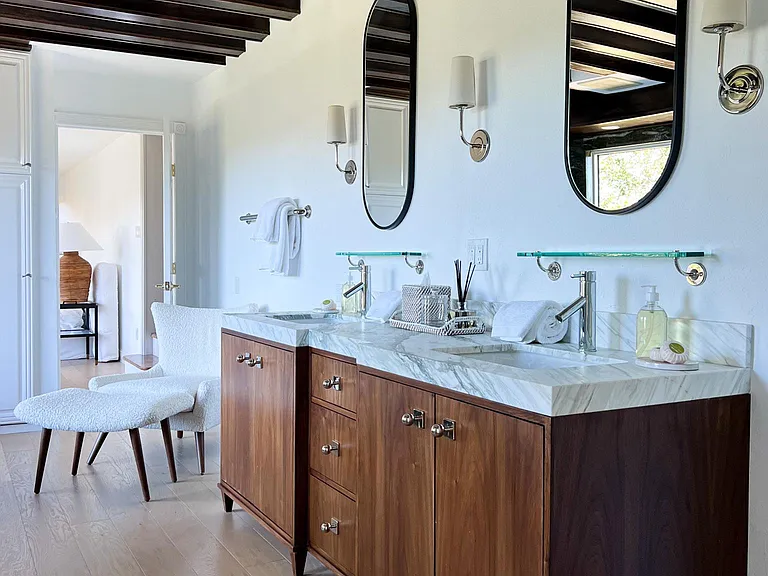 Primary Bathroom features a custom walnut double vanity, jacuzzi soaking tub, glass enclosed shower and double sided glass fireplace. Includes a large walk in closet.