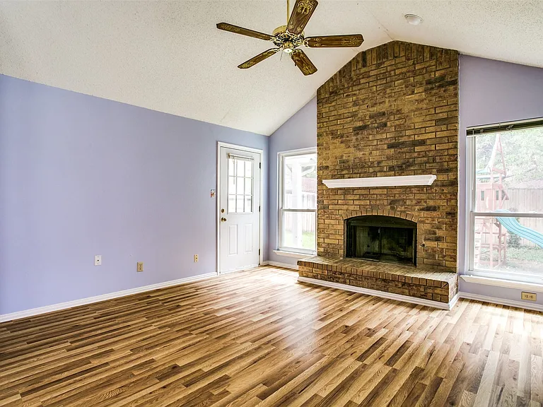 Family room wirh fan, cozy fireplace and exit to backyard. And 2 large windows too.