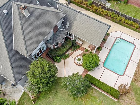 You don't need to travel anywhere for vacation ... you have your own private oasis right here!!! A salt water, gunite pool; a large covered patio features an outdoor kitchen; gas log fireplace; a 65 big screen TV with surround sound; and on the backside of that hedge, plenty of lawn for kids to play.