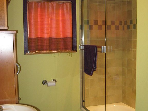 Full bath with porcelain tile tub surround and flooring