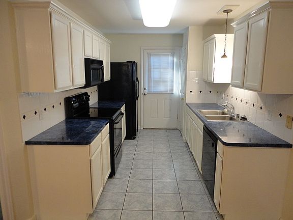 Kitchen with tile flooring, black appliances
