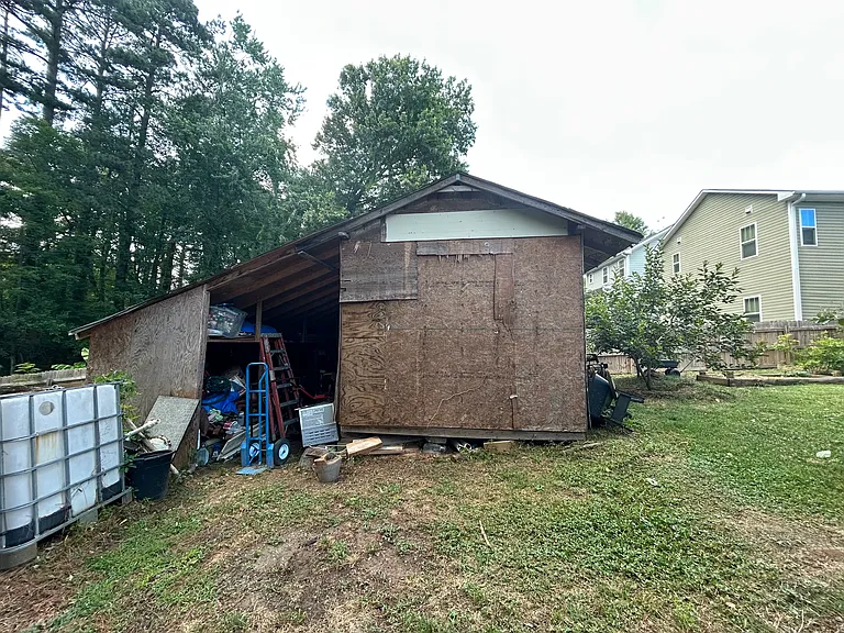 A side view of the shed and another rain storage system. To the left of this image of the shed, you'll find the second half of the backyard/garden.