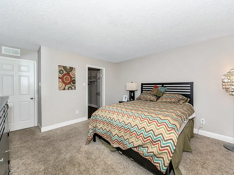 Comfortable primary bedroom with plush carpeting and generous layout.