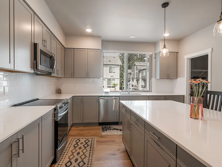 Expansive kitchen with quartz countertop and large island, ideal to host large gatherings.