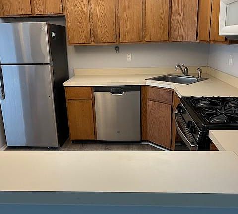 Kitchen with fridge, dishwasher, microwave, oven and cooktop