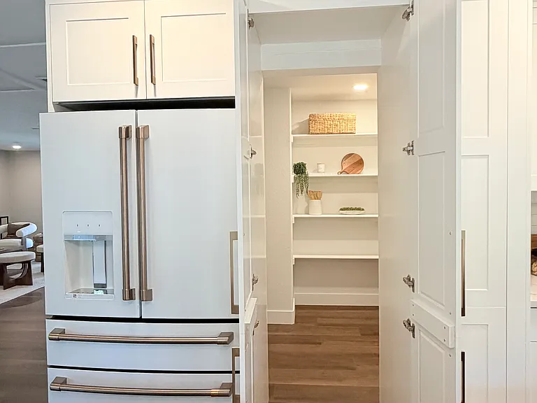 Hidden cabinet-face entrance to large walk-in pantry