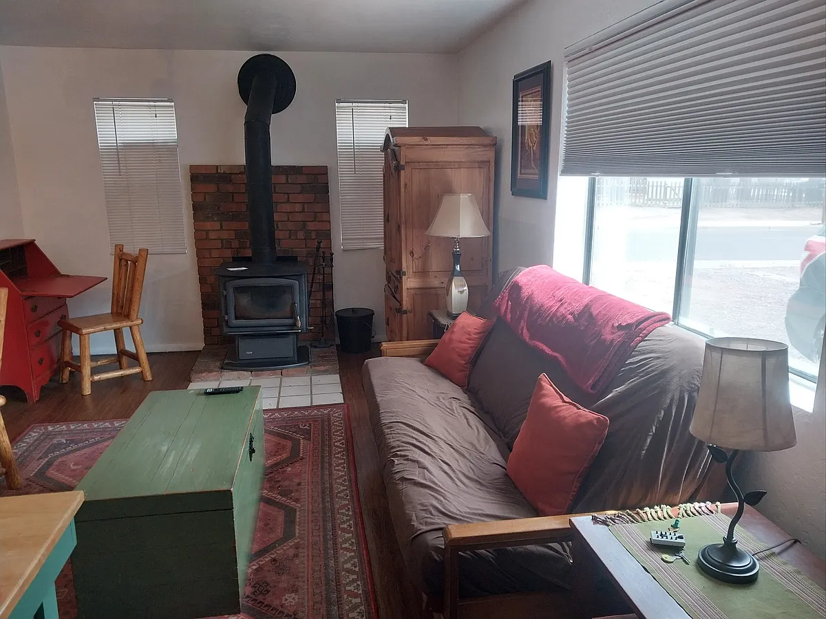 Photo 1 of 11 - N Center St - Flagstaff, AZ Open concept living/dining room with flat-screen TV, work area with desk and wood stove (not the only heat source) - N Center St