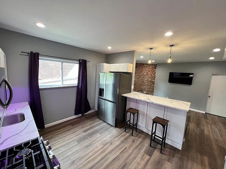 Kitchen with new stainless steel appliances, full-size side-by-side fridge/freezer with icemaker and water on the door, and quartz countertops. Under cabinet lighting can be changed to any color or white.