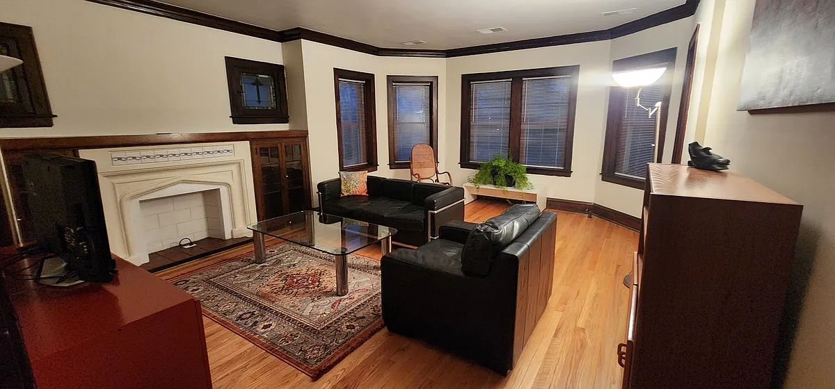 Living Room includes a leather couch and armchair, antique rocking chair, glass coffee table, Oriental rug, two plant stands, credenza, cabinet and large screen TV. - 2018 Lake St #2