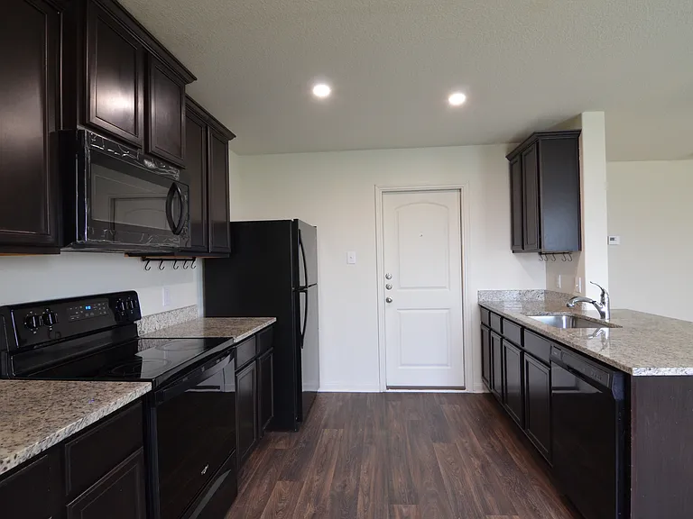 Spacious kitchen with granite countertops, ample cabinetry, breakfast bar, and full appliance package.
