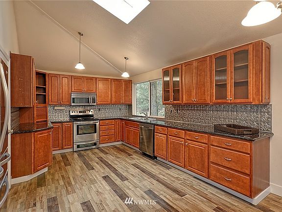 Large kitchen with updated appliances and continuous engineered hardwood flooring throughout main level.